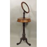 A LATE VICTORIAN MAHOGANY SHAVING STAND having adjustable circular mirror over platform with