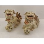 TWO LATE 19TH/20TH CENTURY JAPANESE EARTHENWARE DOGS OF FO open mouthed with left pad on a ball,