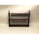 A PART 19TH CENTURY MAHOGANY HANGING BOOK SHELF having three tiers and shaped ends, 54 x 67cm