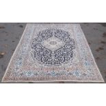 A PERSIAN CARPET, deep blue central field with cream floral design, central motif, deeply