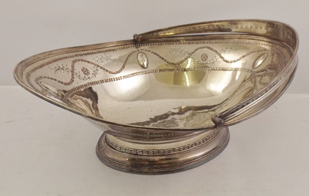 A LATE PERIOD SHEFFIELD PLATE OVAL FRUIT BASKET having swing handle, fretted and tooled with