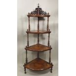 A VICTORIAN WALNUT FOUR TIER CORNER WHATNOT having fretted back, bell turned and ringed uprights,