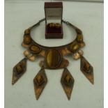 A ZAMBIAN COPPER AND TIGER'S EYE COLLAR, set with eleven cabochon and shaped stones in a tooled