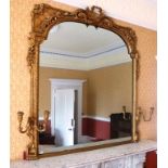 A 19TH CENTURY GILT GESSO FRAMED OVERMANTEL MIRROR, fitted candle sconces, trophy crest to top