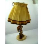 A HUMMEL PORCELAIN TABLE LAMP portraying a girl on a bough with a puppy with a slipper, under a