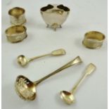 A SELECTION OF SILVER ITEMS comprising; three dissimilar napkin rings, a sifter spoon, two mustard