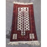 A PROBABLY 1960's/70's PERSIAN RUG (Yak) having pencil multiple desert flower motif adorned surround