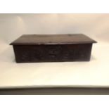 A 17TH CENTURY OAK BIBLE BOX having hinged cover, the front with chip carved lunette decoration,