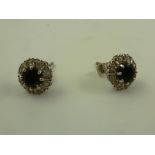 A PAIR OF SAPPHIRE AND DIAMOND EAR STUDS in rhodium finished white gold claw setting with