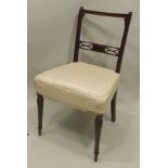 A REGENCY MAHOGANY SIDE CHAIR having reeded uprights, pierced splat, later upholstered seat,