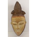 A CENTRAL AFRICAN CARVED WOOD TRIBAL MASK with decorative coiffure and pigmented face, 37cm high