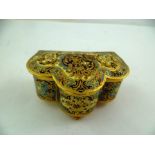 A GILDED CHAMPLEVE JEWELLERY CASKET of serpentine form, stylised floral decoration in blue, pink,