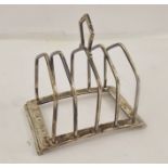 HUKIN & HEATH A SILVER WIRE FOUR-SLICE TOAST RACK, having central handle and twin scrolled feet,