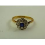 A SAPPHIRE AND DIAMOND FLORAL HEAD CLUSTER RING having single sapphire and eight brilliants