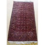 A TURKOMAN DARK RED GROUND RUG with overall stylised decoration, 1.02m x 1.83m