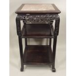 A CHINESE PADOUK WOOD FRAMED THREE TIER STAND having pierced and carved decoration, the top inset