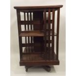 A LATE VICTORIAN/EDWARDIAN MAHOGANY REVOLVING BOOKCASE having square top with moulded edge,