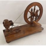 A 19TH CENTURY RIBBON WINDER, the hand cranked wheel on a base board with turned feet, base 38 x