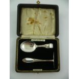 A CASED SILVER CHRISTENING SET comprising a spoon and pusher, in "James Walker Ltd" presentation