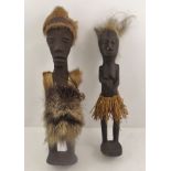 A PAIR OF AFRICAN FIGURES male and female, ebonised and dressed in straw and fur costume, the male