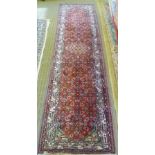 A PERSIAN DESIGN RUNNER having pink ground with overall stylised design with central device in a