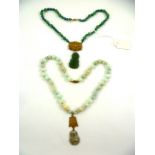 TWO JADE NECKLACES, one nephrite, the other jadeite with Buddha pendants, 48cm long and 42cm long