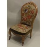 A VICTORIAN SALON CHAIR carved and gilded frame, upholstered in floral Berlin bead work fabric to