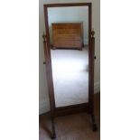 A MAHOGANY FRAMED CHEVAL DRESSING MIRROR, with turned urn finials, on outswept supports with brass