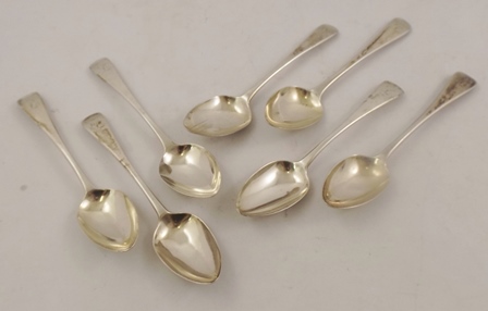 A SUITE OF SEVEN OLD ENGLISH PATTERN GEORGIAN SILVER DESSERT SPOONS each with monogrammed 'L', mixed