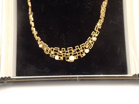 A FANCY 9CT GOLD COLLAR comprised of a graduated series of textured geometric forms and mounted with