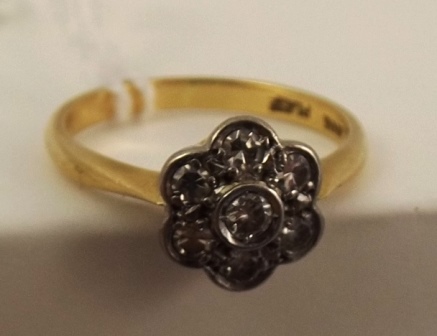 AN EARLY/MID 20TH CENTURY SEVEN STONE CLUSTER RING having floral head and plain wire shank in gold - Image 4 of 4