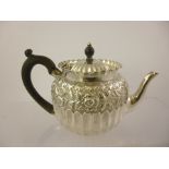A VICTORIAN EMBOSSED SILVER TEAPOT, Birmingham 1888 with ebonised wood handle