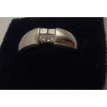 A RHODIUM FINISHED 14CT WHITE GOLD UNISEX RING set with four princess cut diamonds in polished