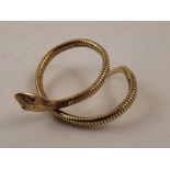 SMITH & PEPPER LTD A 9ct GOLD FLEXIBLE SNAKE BANGLE having tooled head and red stone eyes,