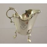 HENRY MATTHEWS A SILVER CREAM JUG having applied scroll rim, panelled tapered body, raised on