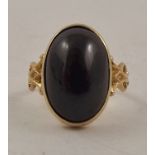 AN ART NOUVEAU STYLE DRESS RING, having oval cabochon garnet in rub-over surround with stylized