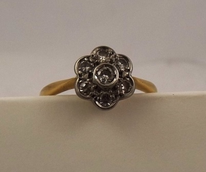 AN EARLY/MID 20TH CENTURY SEVEN STONE CLUSTER RING having floral head and plain wire shank in gold - Image 2 of 4