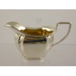 HENRY WILLIAMSON LTD A SILVER CREAM JUG having oval body with fluted corners, rolled rim and wire