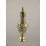 J*** A VICTORIAN SILVER PEDESTAL PEPPERETTE having plain lid and foot with floral scrolled belly,