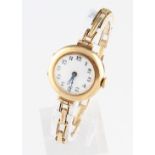 A 9ct yellow gold cased ladies wrist watch, the white enamel dial having hourly Arabic numeral
