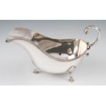 A silver sauce boat by Barker Ellis Silver Company, the plain body having a gadrooned rim with