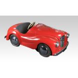 A mid 20th Century Austin J40 pedal car with red coloured body with original wheels, tyres and