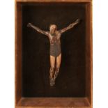 A 19th Century wooden carved sculpture of a crucified figure, wearing a patterned metal band to