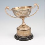 An early 20th Century twin handled trophy, the squat circular tapered body having scroll handles