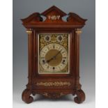 An early 20th Century Lenzkirch oak cased bracket clock, the brass face having ornate foliage design