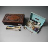 A wooden box containing a quantity of commemorative coins, costume jewellery, two Ronson lighters