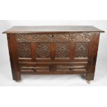 An 18th / 19th Century oak blanket box with carved four panel design to front below floral pattern