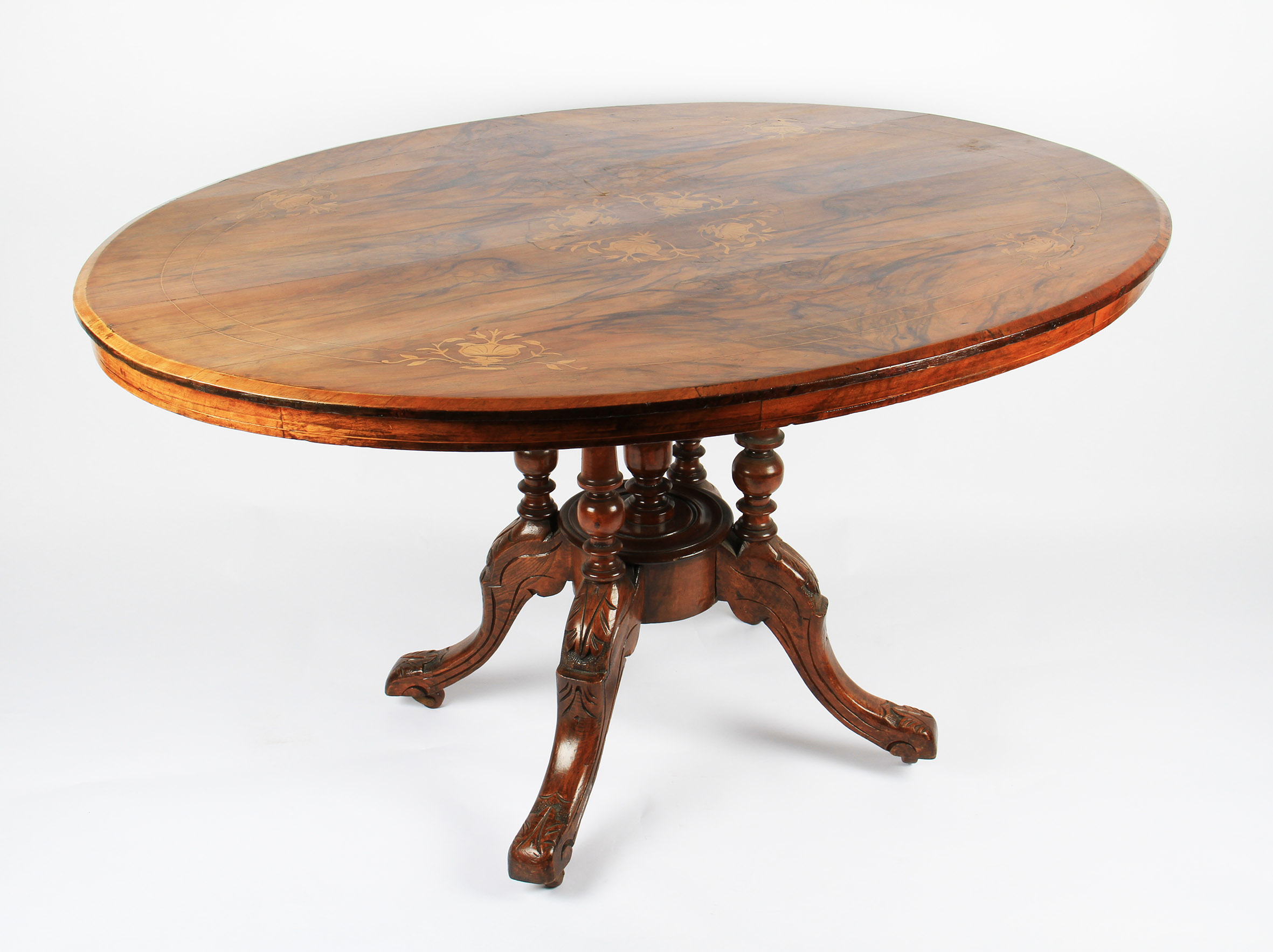 A Victorian oval walnut and inlaid tilt top table on turned pillar base with splayed feet, length