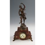 A 19th Century French clock having red marble body with scroll design bezel and feet, dial having