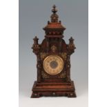 An early 20th Century oak castle shaped mantle clock with carved and turned detailing and finials